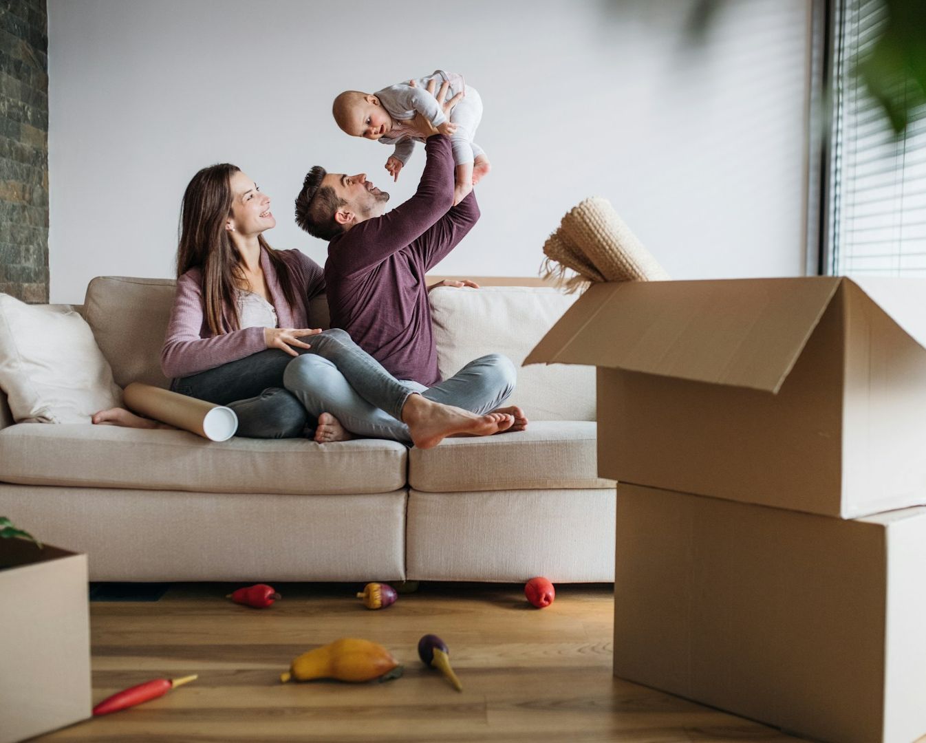 man-and-woman-playing-with-baby-in-newly-purchased-apartment