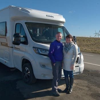 couple-standing-outside-next-to-campervan